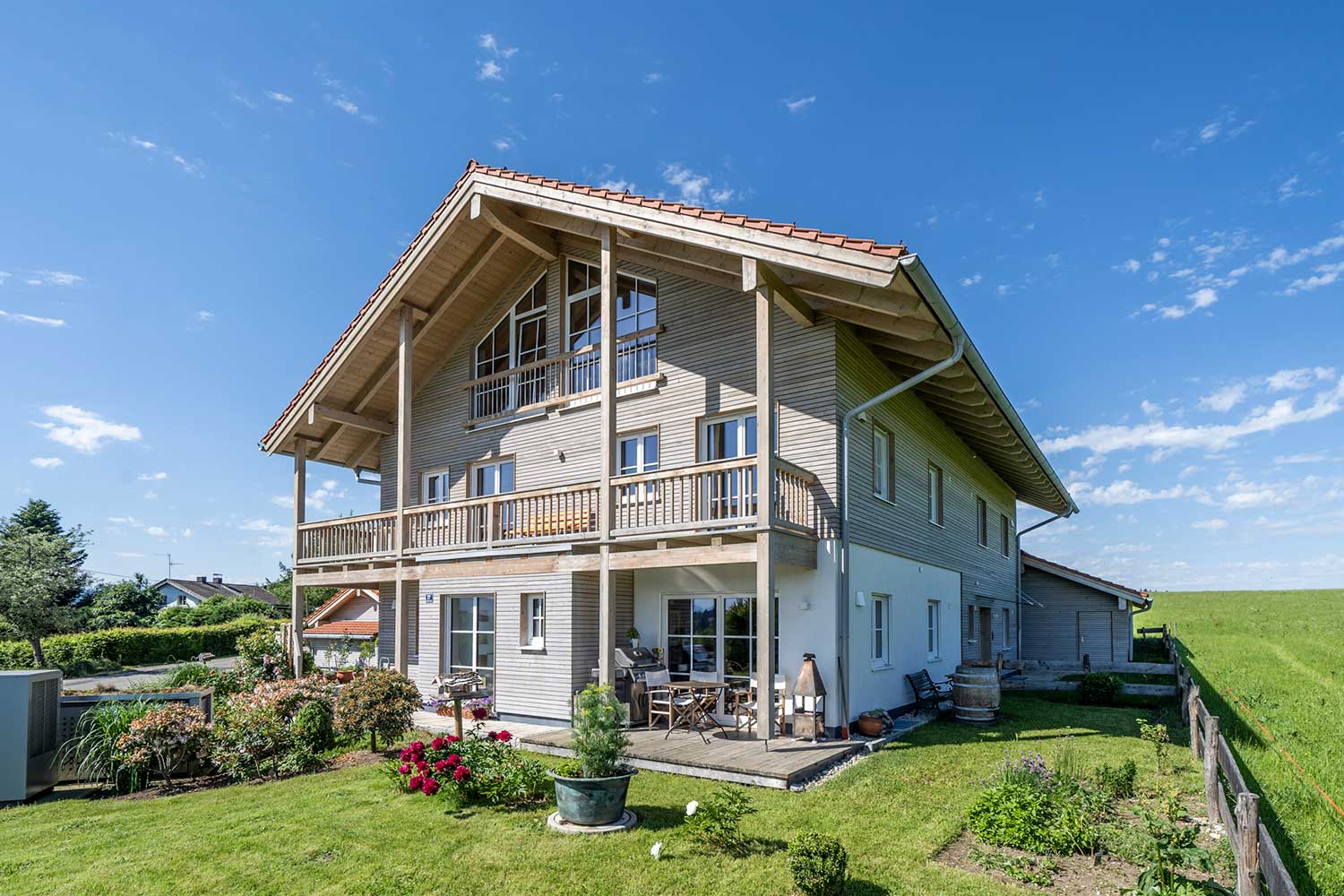 vorder- und seitenansicht eines Einfamilienhauses mit Garten