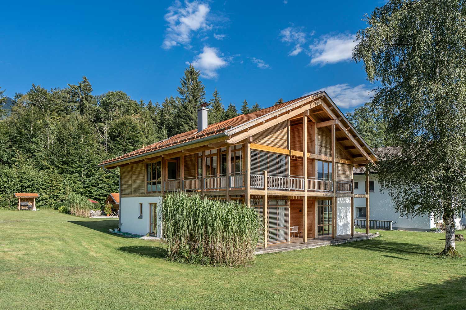 Einfamilienhaus mit grünem Garten und Balkon im Ober- und Dachgeschoss